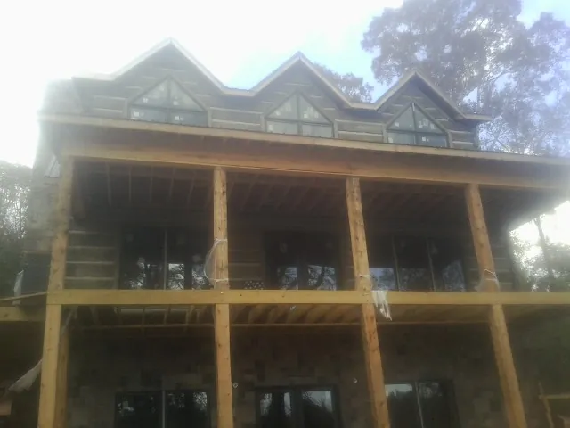 Dormers and porch framing on a large log home under construction — Roof Coating work by our crew in Dover