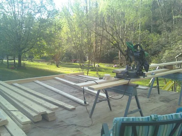 Miter saw and framing lumber on a deck under construction in Dover